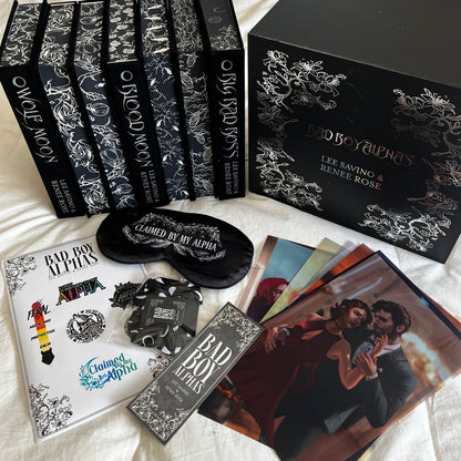 Collection of books titled 'Bad Boy Alphas' with decorative covers and a photo album on a light background.