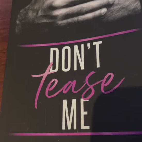 Video of a white woman -- Renee Rose -- opening the "Don't Tease Me" paperback. With a purple thin sharpie she draws a heart, writes "Love and sugar daddy," and signs her name.