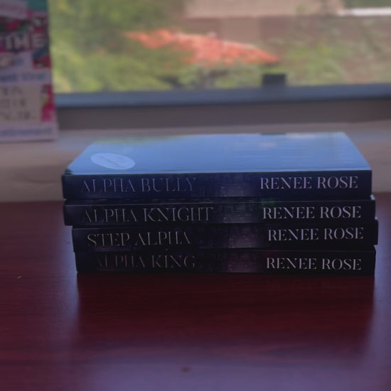 Sped up video. The books from the Wolf Ridge High series are stacked. A white woman -- Renee Rose -- takes the top book with an "Autographed Copy" sticker. She signs it "Love and (wolf) boy next door, Renee Rose"